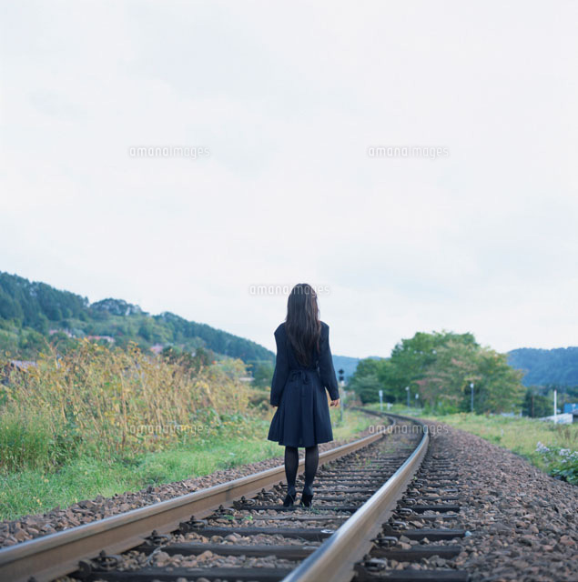 線路の上に立つ女性の後姿 の写真素材 イラスト素材 アマナイメージズ 線路の上に立つ女性の後姿 の写真素材 イラスト素材 アマナイメージズ