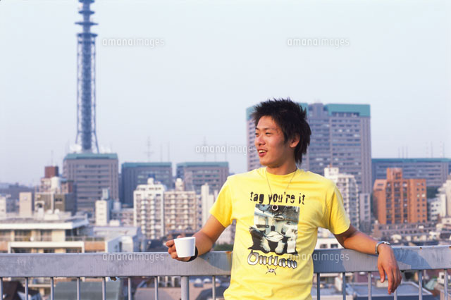 ベランダに寄りかかる若者男性 の写真素材 イラスト素材 アマナイメージズ