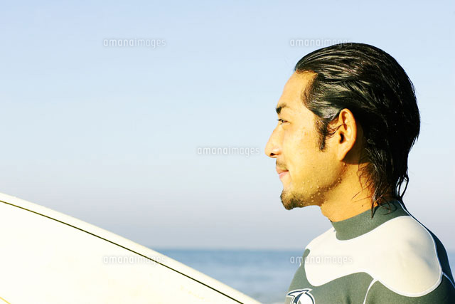 サーフィンボードを持っている男性[02336000695]の写真・イラスト素材