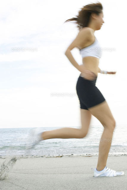 砂浜をランニングをする日本人女性 の写真素材 イラスト素材 アマナイメージズ