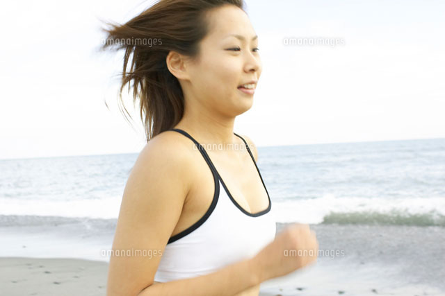 砂浜をランニングをする日本人女性 の写真素材 イラスト素材 アマナイメージズ