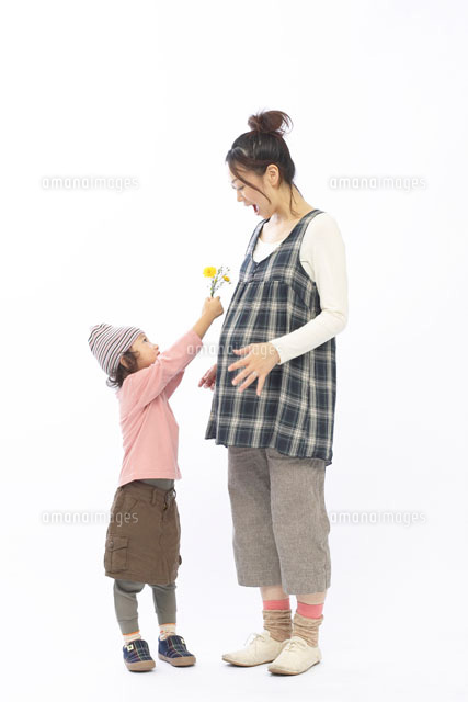 花を妊娠中の母親に差し出す娘 b の写真素材 イラスト素材 アマナイメージズ