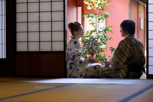 縁側で会話をする浴衣姿の代女性と男性 の写真素材 イラスト素材 アマナイメージズ