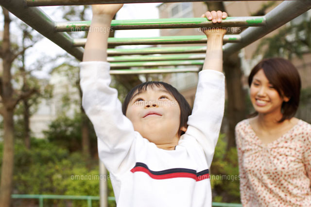 公園のうんていで遊ぶ男の子とお母さん b の写真素材 イラスト素材 アマナイメージズ