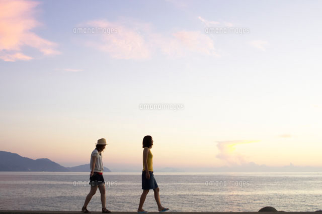 堤防を歩く2人の女の子 の写真素材 イラスト素材 アマナイメージズ