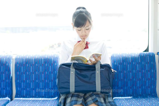 電車の中で勉強する女子高校生 の写真素材 イラスト素材 アマナイメージズ