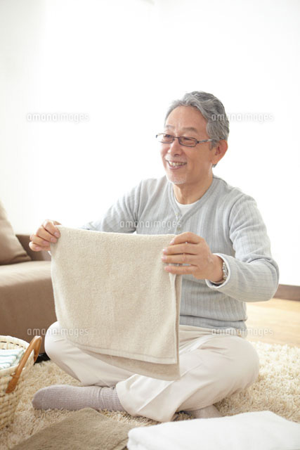 洗濯物をたたむシニア男性 の写真素材 イラスト素材 アマナイメージズ