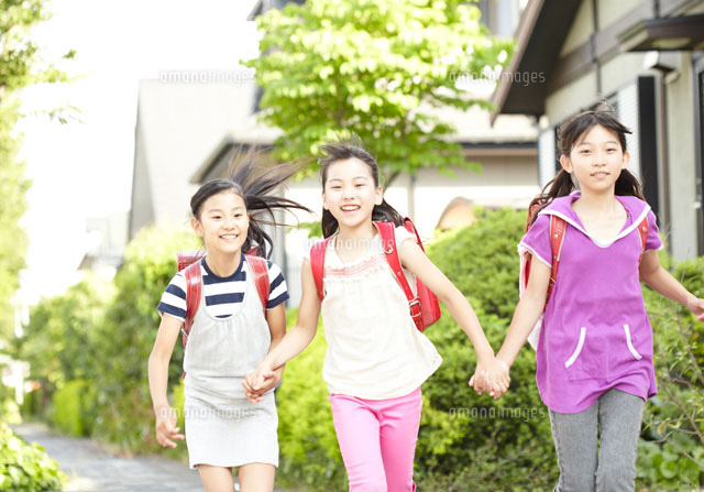 住宅街を手をつないで歩く女の子たち の写真素材 イラスト素材 アマナイメージズ