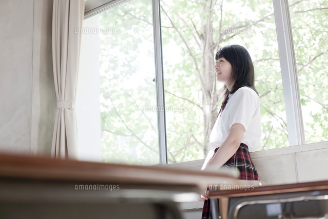 教室の窓際に立つ女子高生 の写真素材 イラスト素材 アマナイメージズ