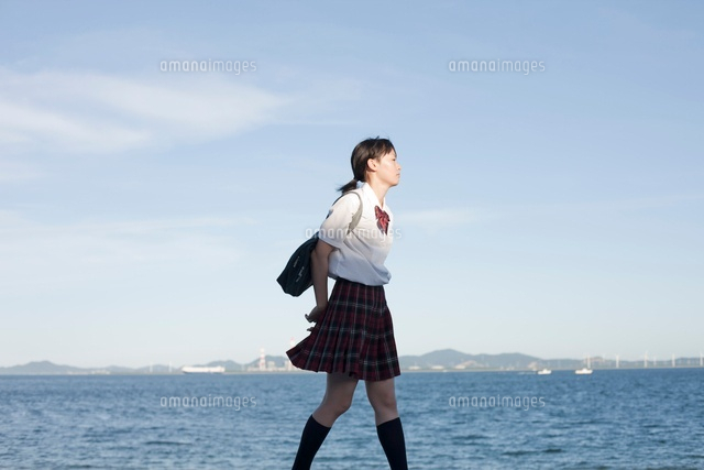 海沿いを歩く女子高生 の写真素材 イラスト素材 アマナイメージズ