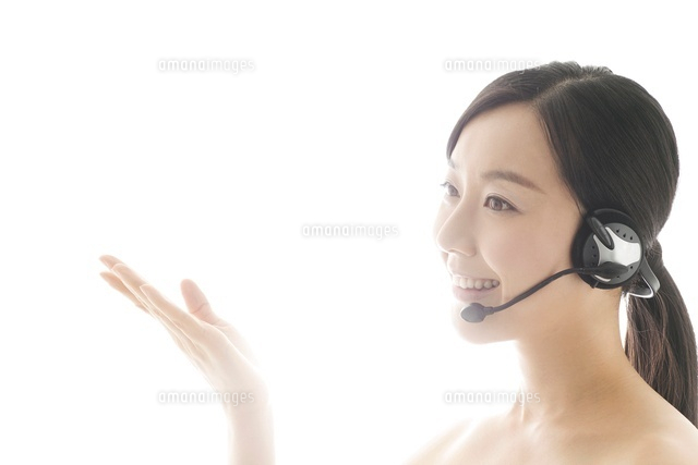 ジェスチャーしながらヘッドセットをつけて話をしている女性 の写真素材 イラスト素材 アマナイメージズ