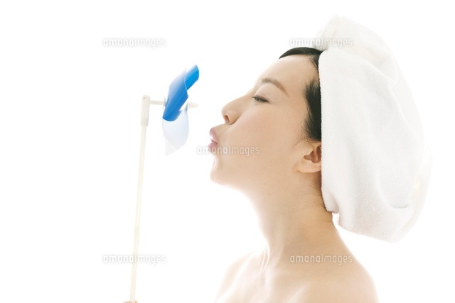 風車を吹いている女性 の写真素材 イラスト素材 アマナイメージズ