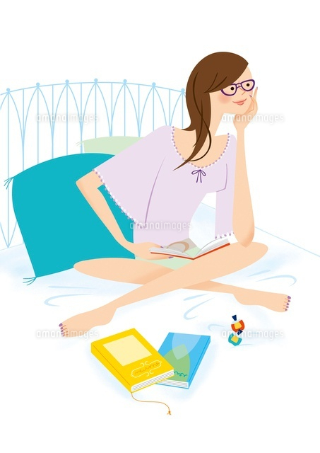 ベッドの上で本を読んでいる女性 の写真素材 イラスト素材 アマナイメージズ
