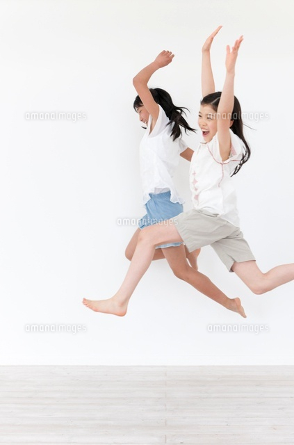 ジャンプする2人の女の子 の写真素材 イラスト素材 アマナイメージズ