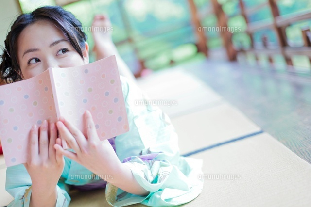 本で顔を隠す浴衣姿の日本人女性 の写真素材 イラスト素材 アマナイメージズ