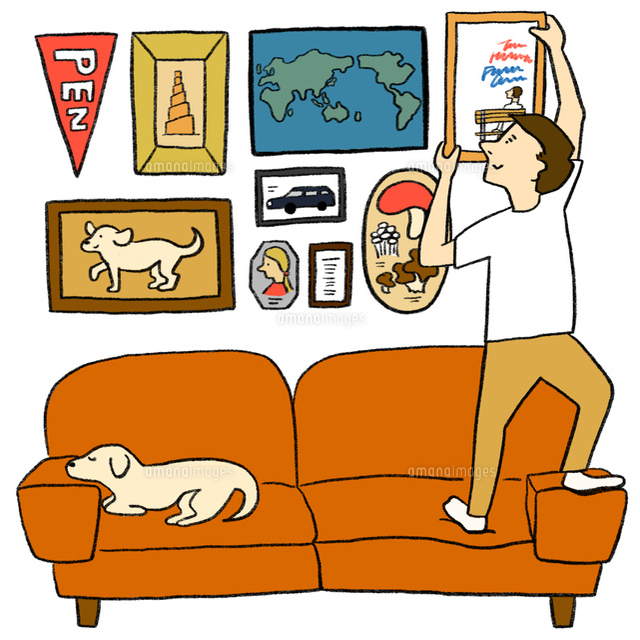 壁に額を飾る若い男性とイヌ の写真素材 イラスト素材 アマナイメージズ