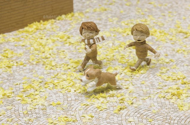 銀杏の落ち葉で埋まった石畳の道を走る二人の子供と犬 の写真素材 イラスト素材 アマナイメージズ