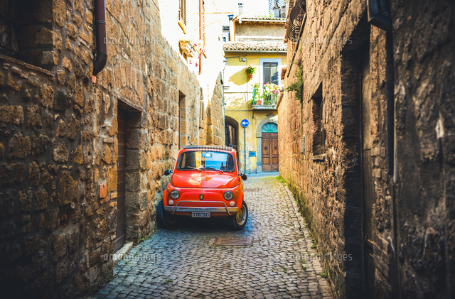 Old red Fiat 500 parked in a narrow alley, classic car[20080010192]の写真 ...