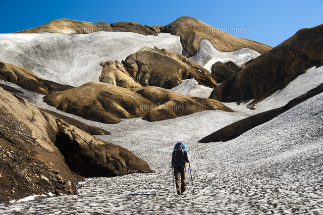 Female hiker, rhyolite mountains covered with snow and ash