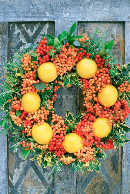木のﾄﾞｱに飾ったオレンジや赤い実のクリスマスリース の写真素材 イラスト素材 アマナイメージズ