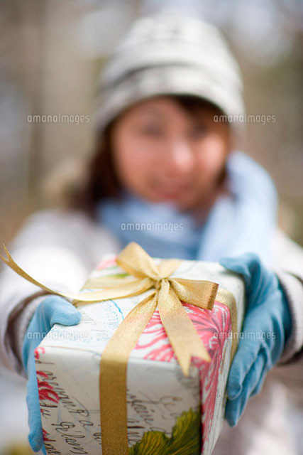 プレゼントを渡すマフラーの女性 の写真素材 イラスト素材 アマナイメージズ
