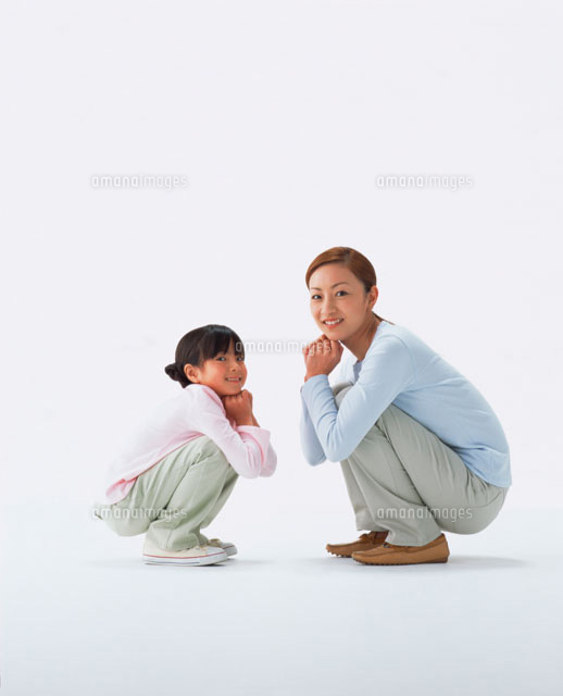 しゃがんでこちらを見る母と娘 の写真素材 イラスト素材 アマナイメージズ
