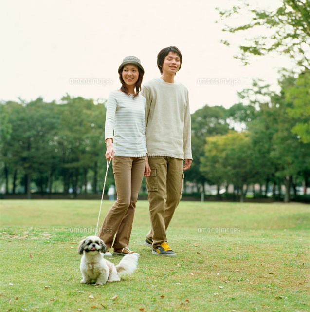 公園で遊ぶ夫婦と犬 の写真素材 イラスト素材 アマナイメージズ