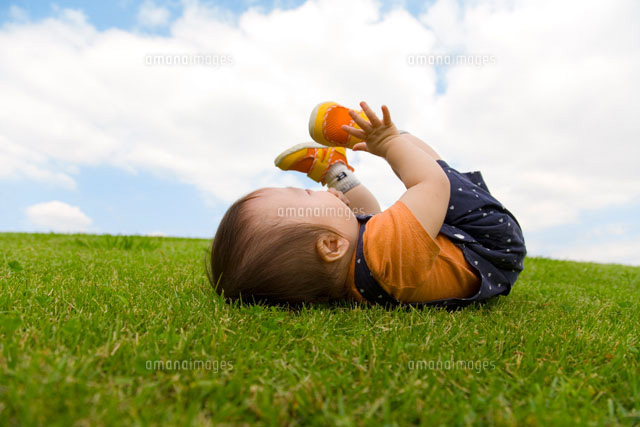草の上でひっくりかえる赤ちゃん の写真素材 イラスト素材 アマナイメージズ