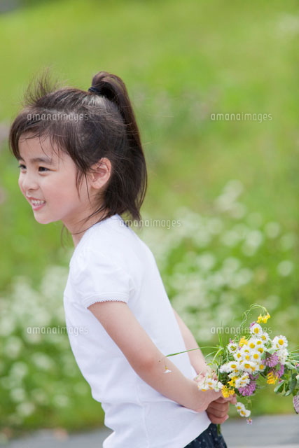 野の花を後ろ手に持つ女の子 の写真素材 イラスト素材 アマナイメージズ