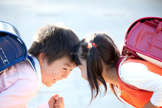 ランドセル姿でおでこをつける男の子と女の子 の写真素材 イラスト素材 アマナイメージズ