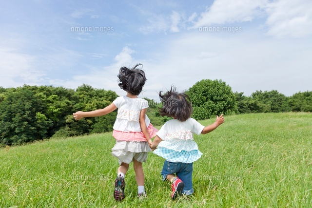 公園を走る姉妹の後ろ姿 の写真素材 イラスト素材 アマナイメージズ