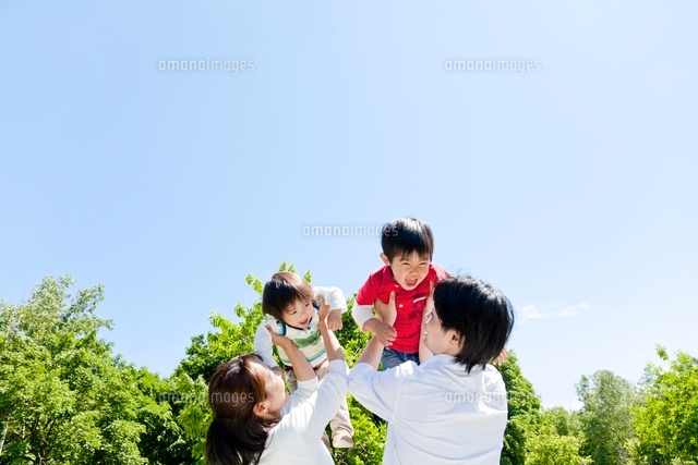 公園で子供たちを抱き上げる両親 の写真素材 イラスト素材 アマナイメージズ