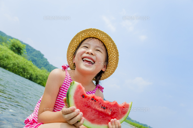 夏の河原でスイカを食べる女の子 の写真素材 イラスト素材 アマナイメージズ