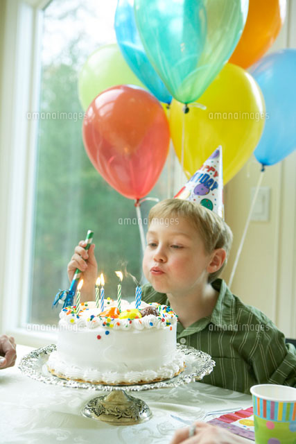 ロウソクの火を消すバースデーボーイ a の写真素材 イラスト素材 アマナイメージズ