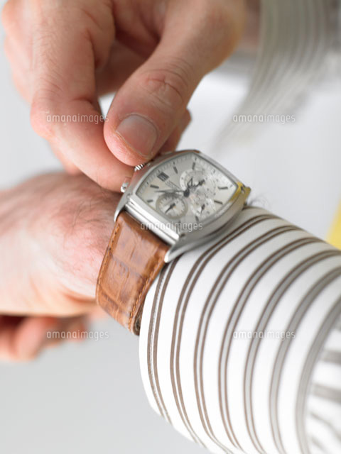 腕時計の針をいじっている白人男性の手 の写真素材 イラスト素材 アマナイメージズ