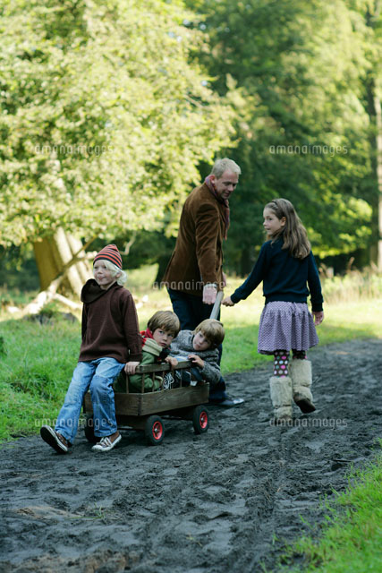 北欧の森を荷車で散歩する父親と子供達 b の写真素材 イラスト素材 アマナイメージズ
