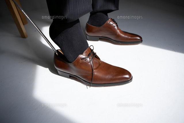 椅子に座って茶色の革靴を履く男性 の写真素材 イラスト素材 アマナイメージズ