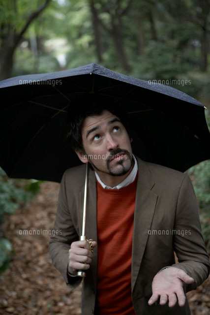 傘をさして雨を確認する男性 の写真素材 イラスト素材 アマナイメージズ