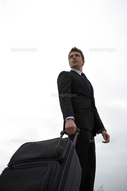 キャリーバッグを運ぶビジネスマン a の写真素材 イラスト素材 アマナイメージズ