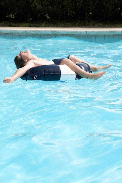 プールで浮き輪で遊ぶ少年 の写真素材 イラスト素材 アマナイメージズ