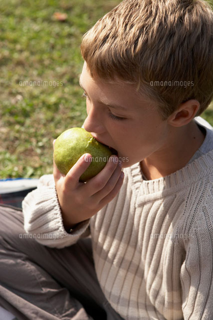 洋ナシを食べる少年 の写真素材 イラスト素材 アマナイメージズ