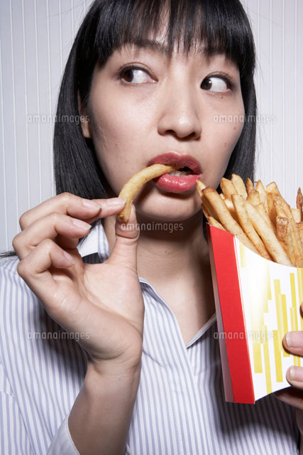 フライドポテトを食べる女性 の写真素材 イラスト素材 アマナイメージズ