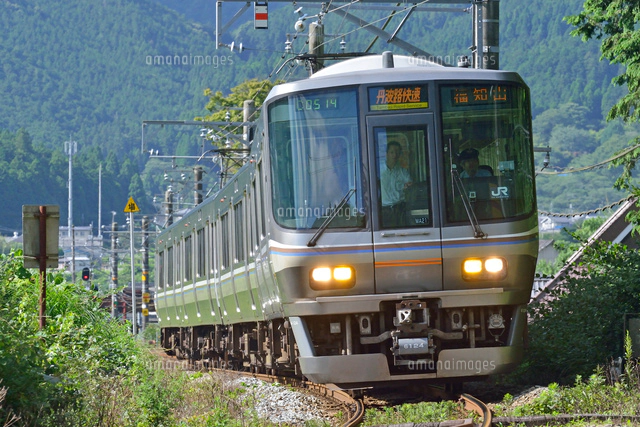 カーブを曲がる福知山線の223系丹波路快速電車[25668002717]の写真