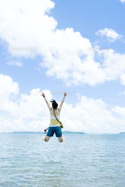 海でジャンプをする日本人の若い女性 の写真素材 イラスト素材 アマナイメージズ