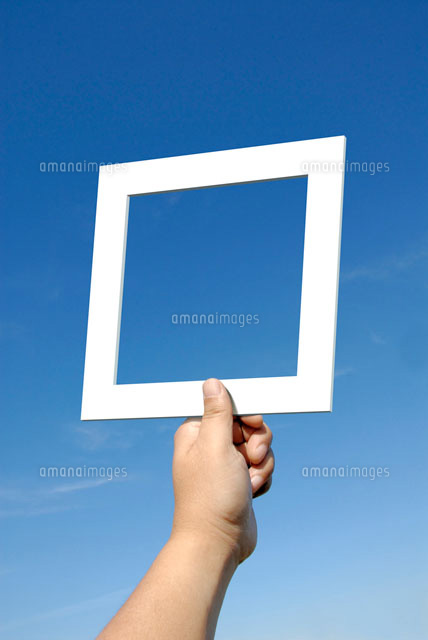青空を背景に正方形の白枠を掲げる手 の写真素材 イラスト素材 アマナイメージズ