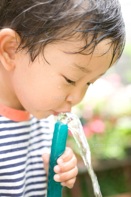 ホースで水を飲む子供 の写真素材 イラスト素材 アマナイメージズ