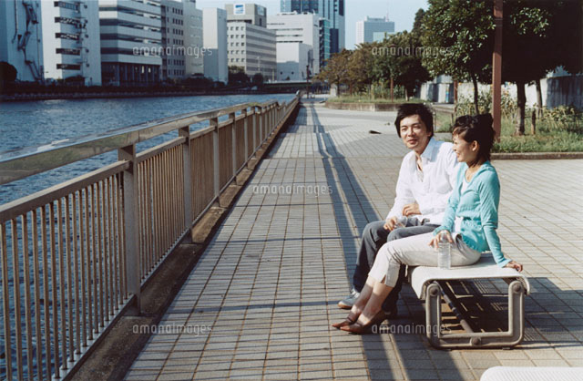 川沿いのベンチに座る日本人カップル の写真素材 イラスト素材 アマナイメージズ