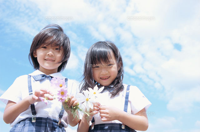 青空の下で花を持つ幼稚園生の男の子と女の子 の写真素材 イラスト素材 アマナイメージズ