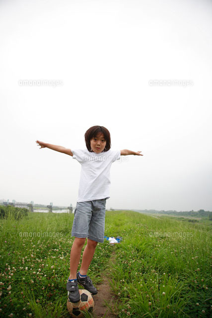 サッカーボールの上に立つ男の子 の写真素材 イラスト素材 アマナイメージズ