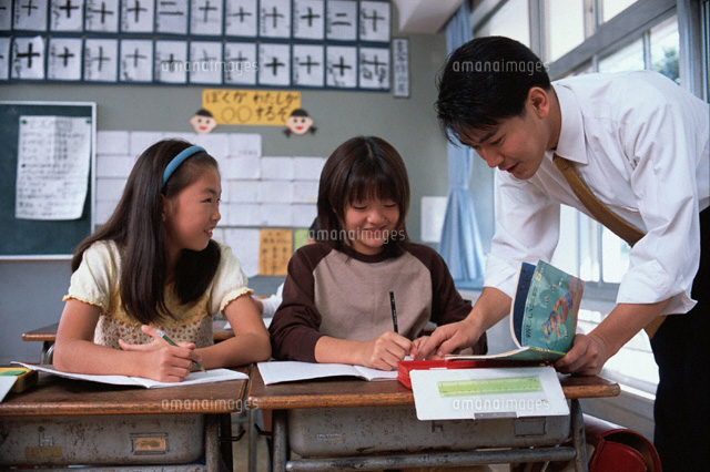 女子小学生の勉強を見上げている男性教師 の写真素材 イラスト素材 アマナイメージズ